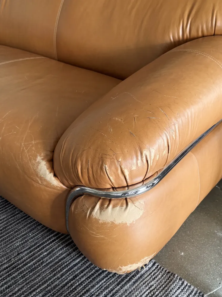 Scuffed camel leather sofa arm before repair